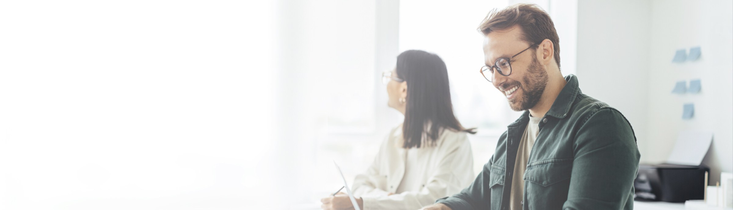 Two Aveta colleagues working together at a shared desk